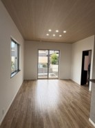 木目が美しい天井と、温かみのある床材が調和する、心安らぐ空間。広々とした窓からは、柔らかな光が室内を満たし、心地よい開放感をもたらします
